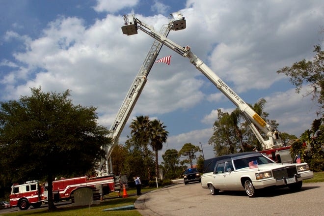 The funeral procession for Lt. Mike Treanor passes under crossed fire truck ladders as it enters Venice Memorial Gardens on Wednesday. Treanor, 47, a 22-year veteran of the Venice Police Department, died March 20 of bone cancer. Treanor was known as a street-smart officer who could turn a group of strangers into friends.