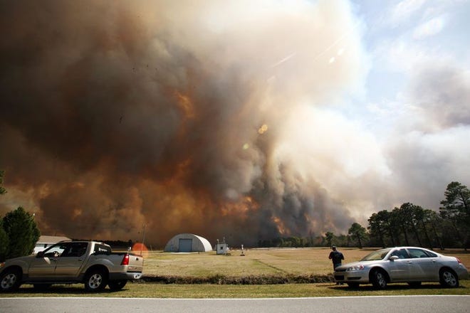 Smoke billows up from a brush fire on Holly Shelter Road near Blue Clay Road on Wednesday.