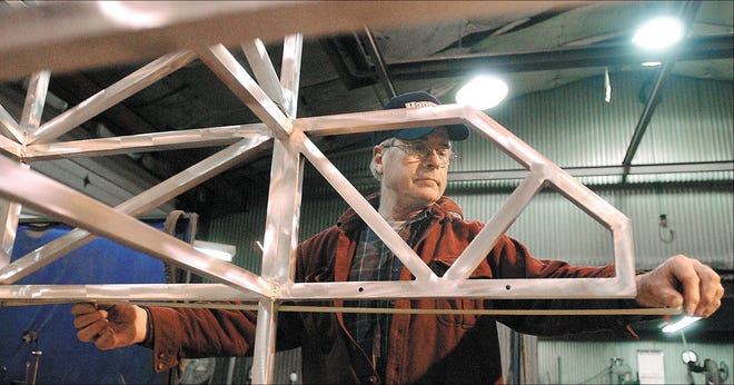 Mike Bishop, superintendent at Hansen Metal Fabrication in Farmington, checks the measurement on an aluminum tube frame.