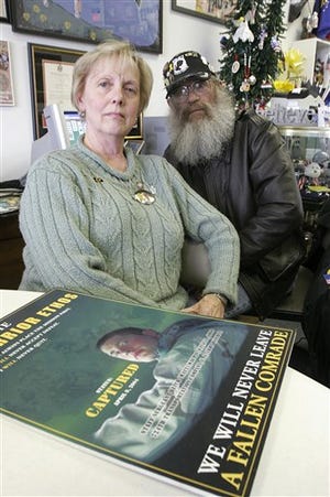 Carolyn and Keith Maupin, parents of missing U.S. Army Sgt. Keith Matthew Maupin, pose with a poster inside the Yellow Ribbon Support Center in this April 6, 2007 file photo near Batavia, Ohio.