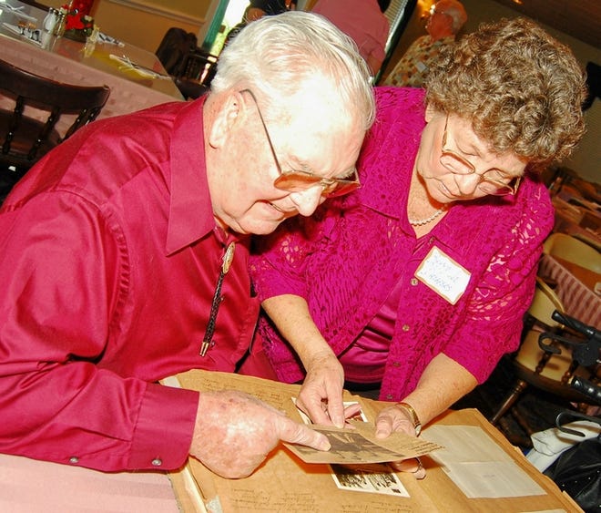Perry and Jo Driggers examine a collection of old clippings and photographs at the 30th all-class reunion of Summerfield School.