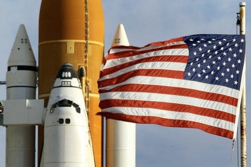 The American flag flies near a space shuttle in this Associated Press file photo.