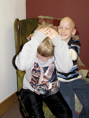 Jacob Mundy, right, messes up the hair of friend Trenton Niemeyer during an interview in the Galva News office. Mundy, 9, is battling Burkitt’s Lymphoma, a form of leukemia.