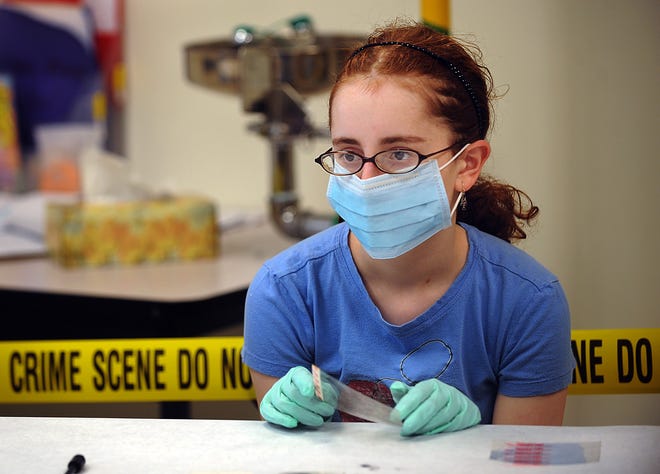 Lydia Stedman, 14, of Westborough listens to Massachusetts State Trooper Emily Phaneuf at a workshop called "CSI: The Real Deal" during yesterday's Women in Science Conference for Girls at Oak Middle School in Shrewsbury.