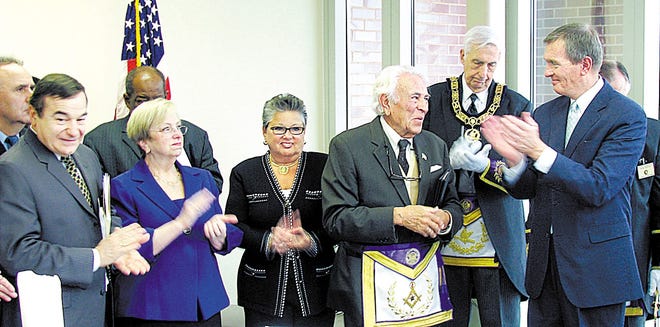 Following an impressive Masonic ceremony, Gilman is applauded by some of the dignitaries present. His wife, the former Georgia Nickles Tingus, stands beside him.