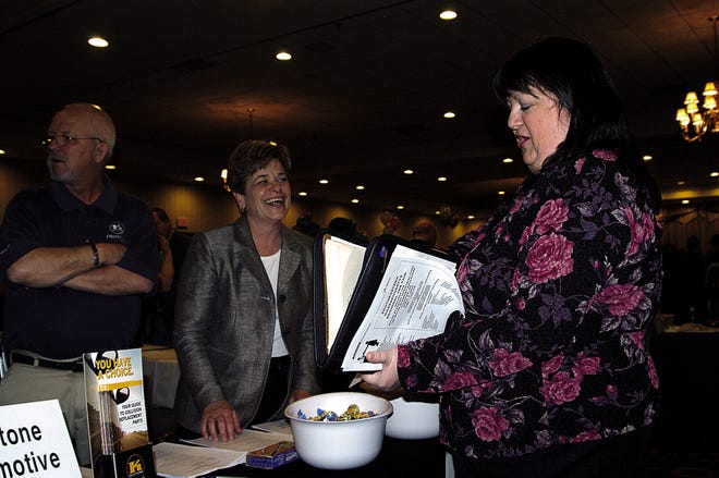 Jan Lombardi, center, human resources manager for the northeast division of Keystone Automotive Industries, exchanges résumé information with a job candidate at Wednesday’s Southeastern Massachusetts Regional Job Fair, held at Taunton’s Holiday Inn.