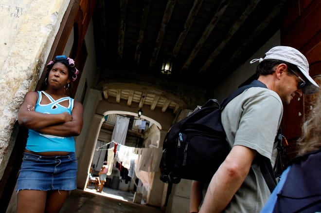 A woman stands at the entrance of her house in Havana, Friday, March 21, 2008. Cuba on Friday authorized government employees to keep state-controlled houses and apartments after leaving their jobs and to bequeath them to relatives, allowing thousands to own their own homes for the first time and potentially laying the groundwork for major housing reform.