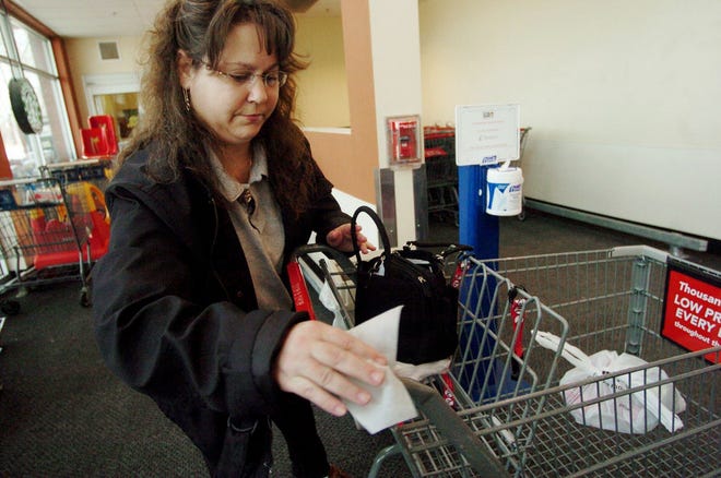 Pamela Boudah of Montville uses a sanitizing wipe to clean her hands then her shopping carriage Thursday, April 10, 2008 at Super Stop and Shop in Montville. She says " I love them. Sometimes the carriage is sticky from children eating snacks."