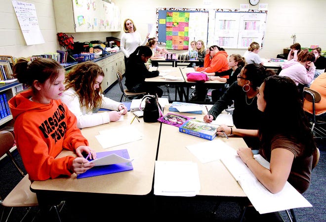 Massillon Middle School sixth- grade language arts teacher Kristi Lutzke works with her all-girl class.
