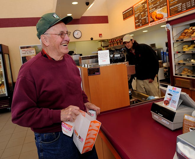 Offering their own enconomic stimulus, participating Dunkin' Donuts stores nationwide gave out a free doughnut with the purchase of a hot coffee for one day only, April 15, Tax Day. At the Dunkin' Donuts on Route 30 in Westborough, Ziggy Porada enjoys picking up his free doughnut Tuesday afternoon.  Porada had mailed his state and federal taxes just this morning.