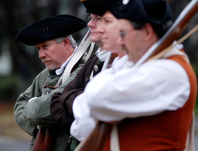 Steve Crosby and his fellow Acton Minutemen practice with their muskets on the Acton Common Saturday for the Patriots Day Parade.