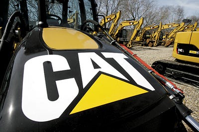 Caterpillar heavy machinery for sale is lined up at Milton Cat in Richmond, Vt., on Wednesday. Heavy equipment maker Caterpillar says demand for its global mining and energy products pushed its first-quarter earnings up 13 percent.