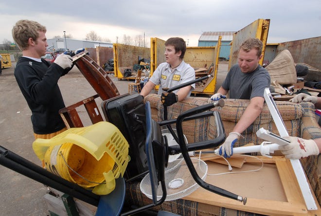 From left, Matt Mulder, Leon Foster and Matt Reyenga unload items from a vehicle at Chef Container in Laketown Township Saturday during Project Pride. The event gave Holland residents a chance to unload and recycle appliances and other items that were too big or too environmentally hazardous to dispose of in regular trash collections.