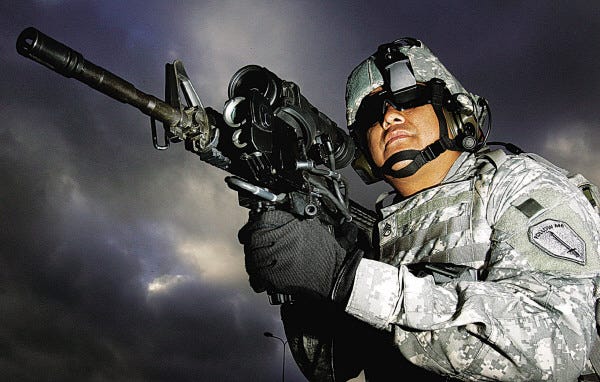 Kirsty Wigglesworth/Associated Press file photo
U.S. Army Staff Sergeant Ruben Romero, from Fort Benning, Ga., demonstrates new technology making use of a magnifying video camera and thermal imaging on the M4 weapon, made by Colt Defense of Hartford, Conn., during a 2006 demonstration.