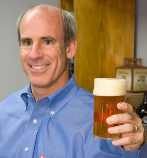Mayflower Brewing Co. founder and President Drew Brosseau holds a glass of Mayflower's Mayflower Pale Ale in the Plymouth facility.