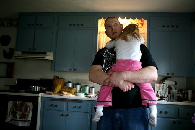 MMA fighter Aaron Caw holds his daughter Kaylee, 3, at his home in Zanesville, before going to a training session. Aaron is a single father, and his grandparents help look after his kids while he is training and working nights at a local hospital.