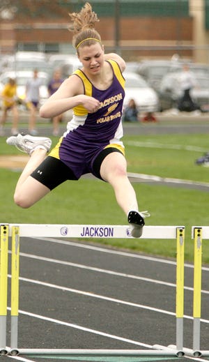 Jackson’s Courtney Armsey clears the final hurdle on her way to winning the 300-meter hurdles against Perry Tuesday afternoon.