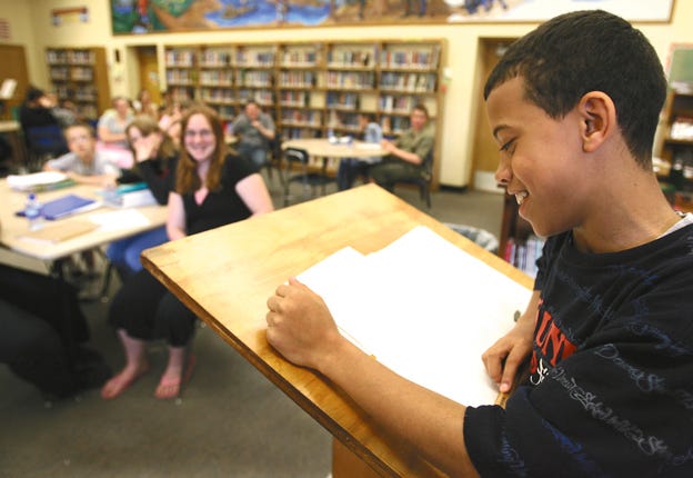 Lombard Middle School eighth-grader Latrell Thompson reads a poem to those assembled in the school library Wednesday afternoon. Lombard held a poetry slam to celebrate National Poetry Month.