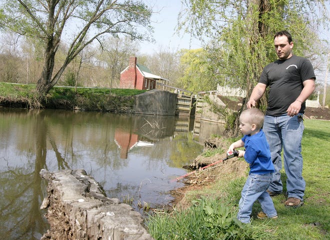 Two-year-old A.J. Sandavao casts his line into the Ohio-Erie Canal at Lock IV with a little help from his dad, Ryan. They were testing the waters, so to speak, for the annual trout derby Saturday. The waters will be stocked with 2,500 rainbow trout that are 9 to 11 inches in length.
