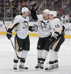 Evgeni Malkin (71) celebrates one of his two power play goals with teammates during the Penguins' 5-3 win in New York Tuesday. (AP)