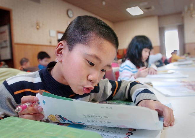 Neo Liu, 7, practices reading Chinese aloud.