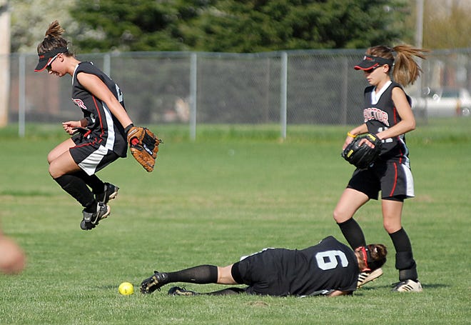 Thomas R. Proctor shortstop Kayla Kipper, left, leaps over the ball and left fielder Taylor Loy (6) after a near collision chasing down a ball hit by Rome Free Academy's Lyndsey Brognano in the third inning of a high school softball game Monday at Proctor High School in Utica. Moving in at right is center fielder Kaitlyn Brown. RFA won 2-1.