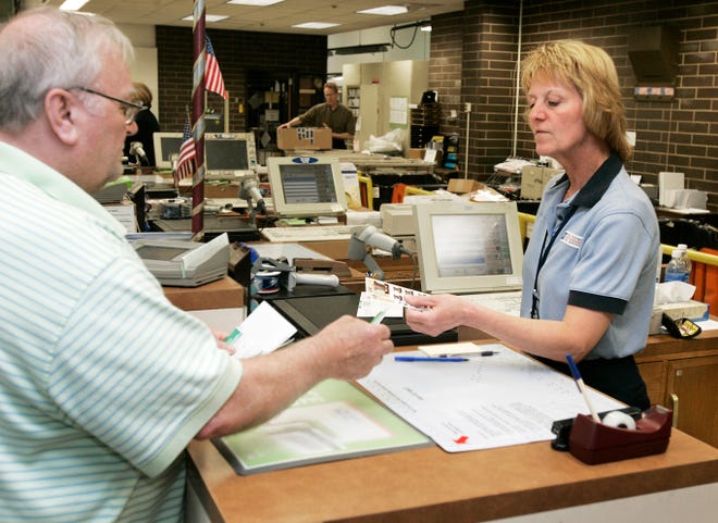 William Bostwick of Rockford buys a pack of forever stamps from U.S. Postal Service retail sales associate Sally Henze of Davis on May 8, 2008, at the U.S. Post Office on Harrison Avenue in Rockford.