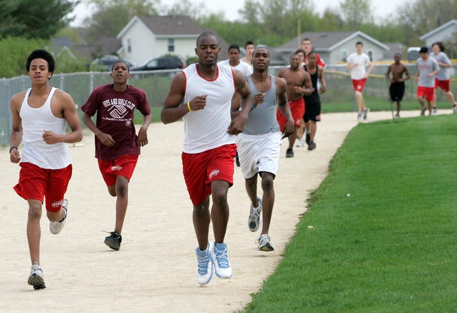 Lawrence Scott (front left) and Keith Dismuke (front right) lead a warm up run Monday during track practice at Jefferson High School in Rockford.