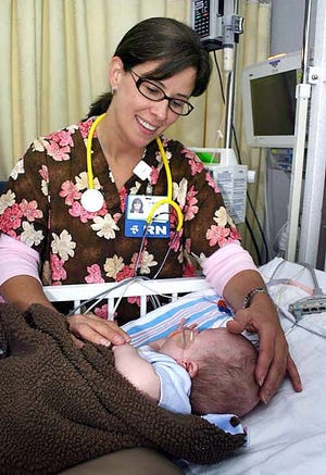 Kathy Peterson, RN PICU, comforts a tiny patient.