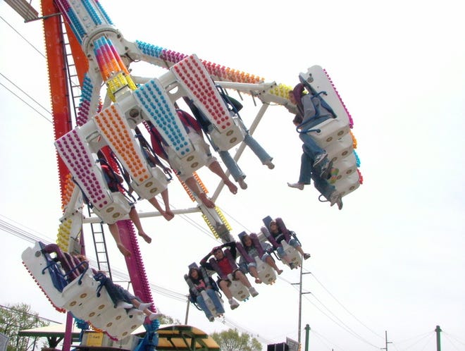 Visitors take a ride at the Tulip Time carnival Thursday night. Michigan’s “Pure Michigan” tourism ad campaign is lauded by critics, but industry forecasters still anticipate a rough year for travel-dependent businesses.