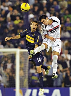 Ricardo Jiménez (D), del Atlas de México, disputa el balón con Rodrigo Palacio (I), de Boca Juniors de Argentina, durante el partido de ida de los cuartos de final de la Copa Libertadores de América.