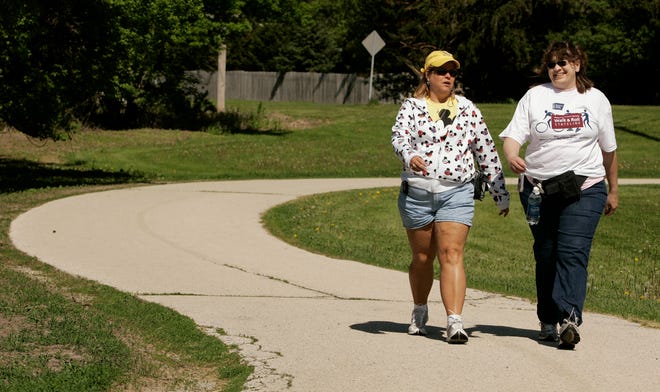 Carol Serafin (left) and Laurie Kloeckner walk May 17 during Walk and Roll, an American Cancer Society fundraiser, held at Midway Village Museum.