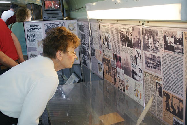 Germaine Binns of Blissfield reads information about the Midwest soldiers and their role in the World War II Prisoner of War experiences on Saturday in a traveling exhibit called “Behind Barbed Wire: Midwest POWs in Nazi Germany,” displayed in a BUS-eum that made a stop at the Schultz-Holmes Memorial Library in Blissfield.