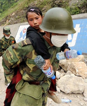 A Chinese soldier carries a girl to a safer location on Saturday.