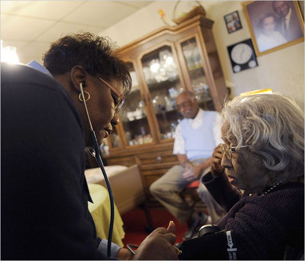 Rose M. Whittle, left, a registered nurse, performs checkups on Helen Bell and her husband, Readus, at their home in Pittsburgh.