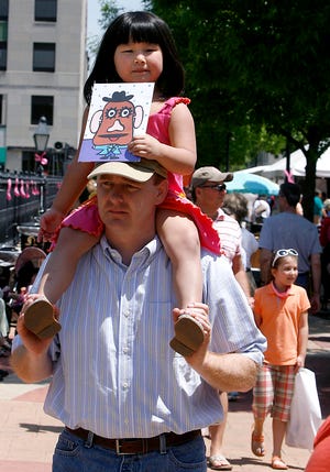 Lia Fultz, 4, gets a bird’s-eye view of the Old Capitol Art Fair from the shoulders of her father, Dan, after making a purchase Saturday in the children’s tent. It’s a portrait of Mr. Potato Head.