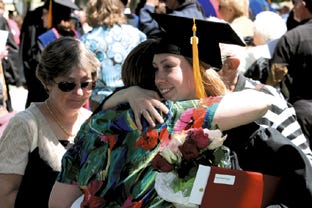 Monmouth College graduate Megan O’Connell, a psychology and Spanish major, hugs her aunt, Nancy Freitag, after Sunday’s commencement ceremony.