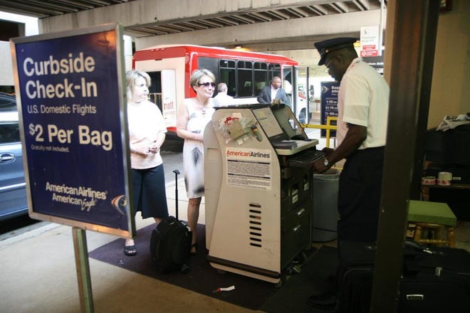 Patricia Benson of Prosper, Texas, left, helps her mom, Susan Thomas of Newport Beach, Calif., check her bags with American Airlines Skycap Ernest Frimpong at Terminal A at Dallas-Fort Worth International Airport in Dallas, Wednesday, May 21, 2008. American Airlines on June 15 will start charging $15 for the first checked bag, cut domestic flights and lay off possibly thousands of workers as it grapples with record-high fuel prices. (AP Photo/David Pellerin)