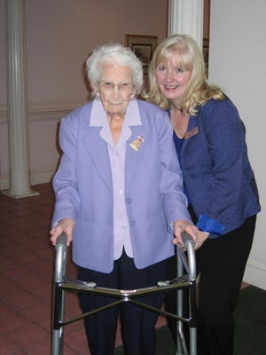 Linda Malvoyt, executive director of John Wesley Villas retirement home, stands with resident Lillian Elkins, 99.