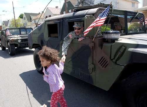 The Times/SALLY MAXSON Scott Ryan of the 307th military police in New Kensington shakes 4-year-old Ripley Battle's hand during the parade celebrating Aliquippa's centennial Saturday.