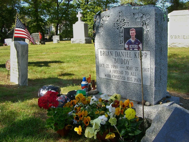 Flowers and mementos decorate the grave of Brian Kerr at St. Stephen's Cemetery in Framingham on Sunday. Family and friends observed the first anniversary of the Framingham 16-year-old's death at a Milford quarry.
