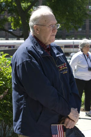 Bill Collett holds a flag at Waltham's Memorial Day ceremony.