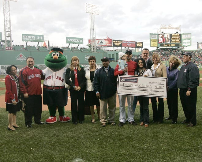 From left to right are Superintendent Carol R. Johnson, Monument High School Headmaster Jonathan Pizzi, Wally the Green Monster, Excel Headmaster Ligia Noriega, Odyssey Headmaster Virginia Ordway, BPS Athletics Director Ken Still, Manny and Ana Delcarmen and their daughter, Steve Coyle from Game On!, Lindsay Curtis of the Lyons Group, Hyde Park Cooperative Bank President and Chief Operating Officer Carol McClintock and Hyde Park Cooperative Bank Chairman and Chief Executive Officer Norman B. Williamson.
