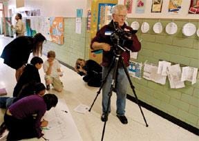 CHIEFTAIN PHOTO/JOHN JAQUES Nicholas DeSciose (foreground), a videographer for Crystal Peak Design, records a video, while Susanne Arens shoots still photographs of students at the Pueblo School for the Arts and Sciences.