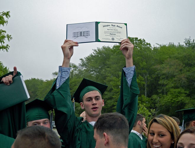 Dlian Roberts holds his diploma high after the Abington High School graduation.