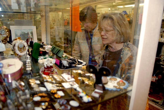 Pat Hoge of Westlake, Ohio, left, and her sister, Marcella Coniam of Manchester, look at antiques at the Antiques Marketplace in Putnam.