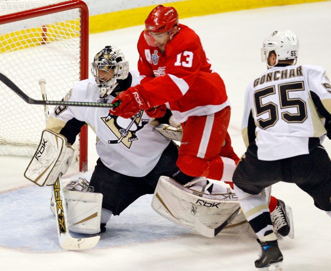 Detroit Red Wings' Pavel Datsyuk (13) jumps between Pittsburgh Penguins goalie Marc-Andre Fleury and Sergei Gonchar, from Russia, during first period of Game 5 of the NHL Stanley Cup Finals Monday, June 2, 2008 in Detroit.