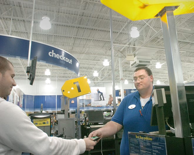 Brendan McNiff, right, a cashier at Best Buy in Braintree, helps a customer. Retailers like Best Buy might not like the news that the state is unlikely to have a tax holiday this summer.