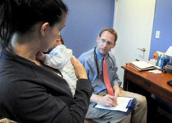 Dr. Leif Norenberg interviews Jessica Lyman of Sandwich as part of his exam of her 4-week-old son, Dylan Vacher, at the new evening clinic.