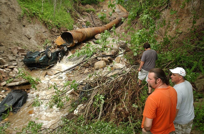 Dennis R.J. Geppert/The Holland Sentinel
From left Jason Stressman, Jeff Burt and Conner Burt look at the destruction caused by heavy rain and flooding over the weekend.